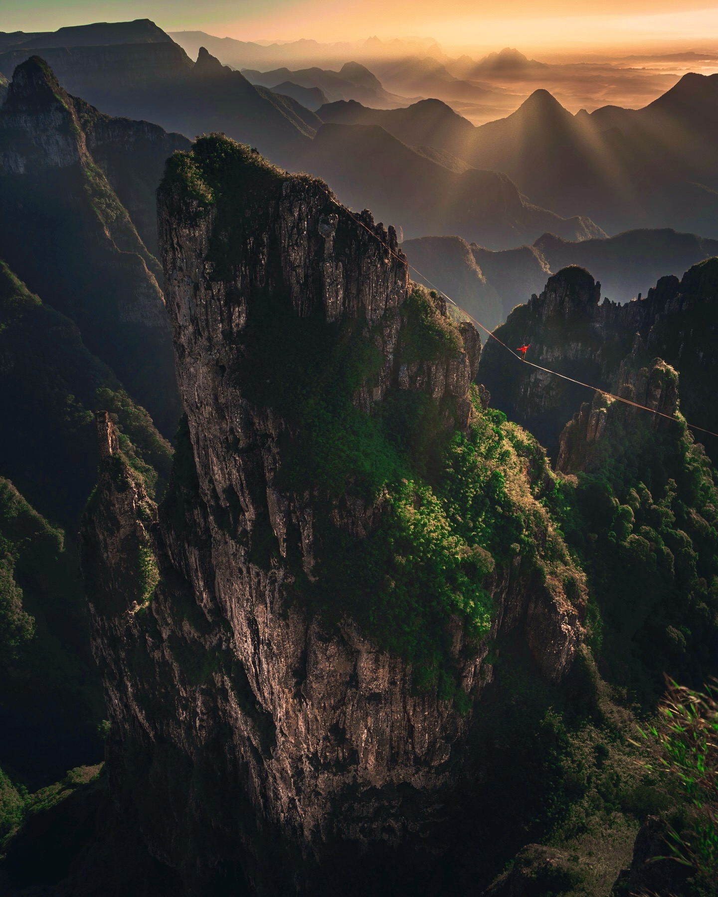 Highlining at sunset between mountain towers in China